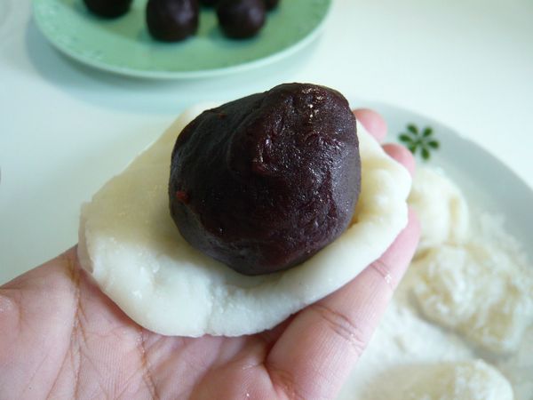 將糯米皮展開將內餡包入，底部捏緊，表面沾些日本太白粉避免沾黏