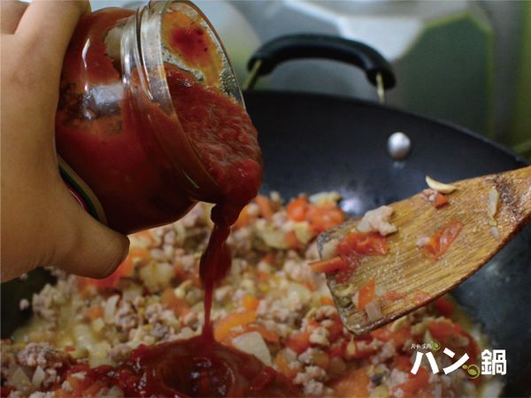 倒入義大利麵醬(400克)提味上色，可分次倒入避免過量