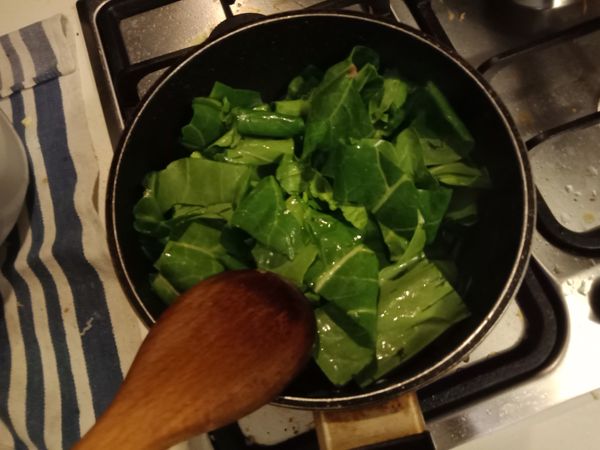 倒入芥藍菜葉，加10ml 水，用鍋鏟拌炒直到葉菜軟化。