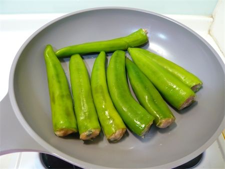 步驟5鍋中加入一大匙油，放入添好餡的青椒煎煮一下