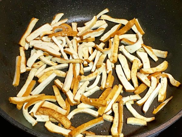 鍋內倒入1大匙的油加熱後，將作法1的豆干絲放入略煎上色後取出。