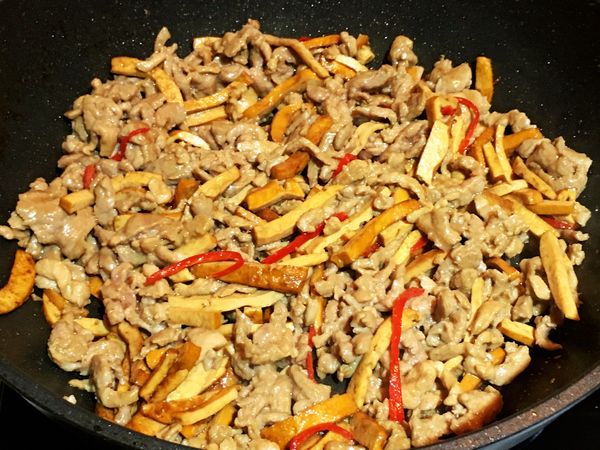 放入蒜末、辣椒絲和蔥白段爆香，再將步驟4的豆干絲放入和醬油膏、水及糖倒入輕輕拌炒(以免豆干斷掉)，炒至醬汁收汁。