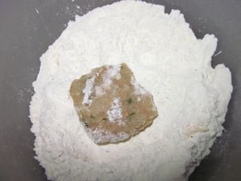 準備兩只容器, 一只放入麵粉和黑胡椒; 另一只打入兩顆蛋. 將肉球稍微壓扁.