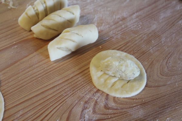 取適量的內餡揉成小長條，橫放在麵皮的刀痕上。