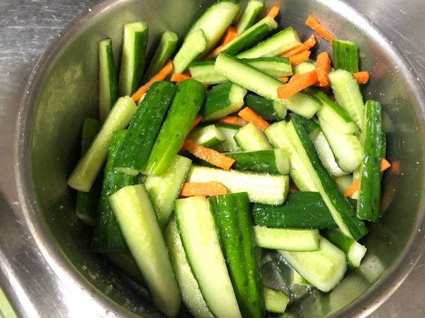 依照個人喜好，將小黃瓜切段或切片皆可，胡蘿蔔切成與小黃瓜相同的大小，撒上約2小匙鹽巴，混合均勻後靜置約30分鐘至1小時。