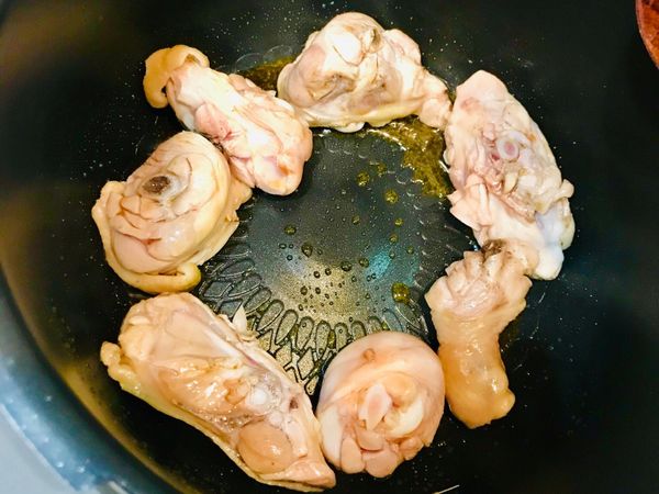 萬用鍋免洗再次選擇「烤雞」模式烹調，熱鍋後倒入一大匙麻油，雞皮向下放入鍋中。