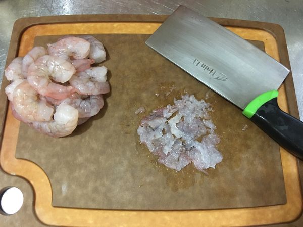 弄乾的蝦仁放粘板上，一隻隻用菜刀的側面壓，壓成泥。
ps：也可以一隻隻蝦仁用菜刀側面（比較重的剁刀）用力拍下去，一隻拍一下即成泥，但是小心少許蝦泥會噴到身上，若怕噴到身上，也可以在蝦仁上蓋塑膠袋，再用力拍，就比較不會噴到身上了。