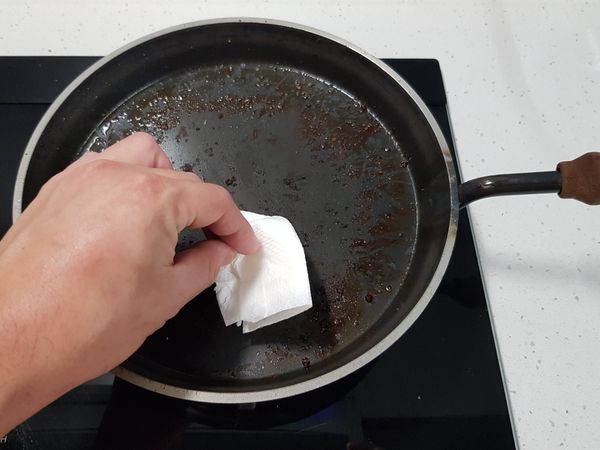 用廚房紙巾將鐵板鍋內的肉渣稍微擦拭。