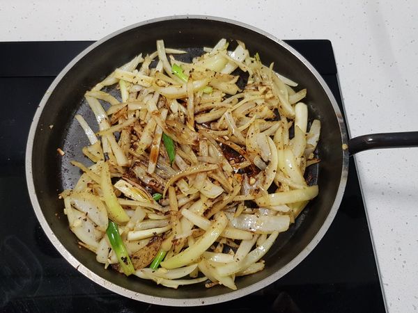 炒至洋蔥絲呈現微焦狀時加入醬油、味醂，拌炒均勻。