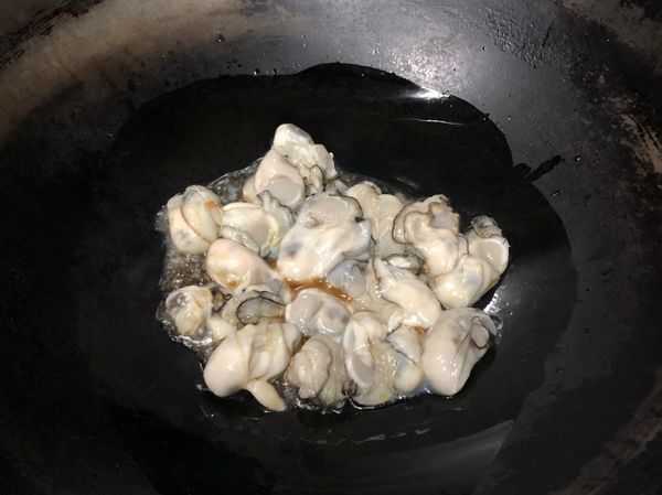 鍋裡放入麻油，將蚵仔下鍋煎一下，時間大概幾分鐘，可明顯看到蚵仔微微變白縮水時，加入蔥蛋液一起煎熟。