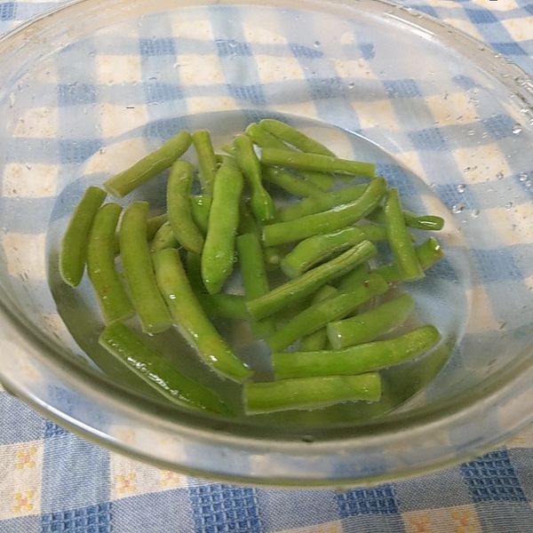 將四季豆泡在冷開水中備用。