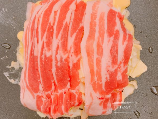 取適量拌好的料放在烤盤上，弄成圓形，喜歡方型就弄成方的，上面舖上五花肉片，蓋上鍋蓋悶煎。