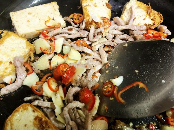 續入蒜、辣椒、豆豉，炒至香氣出來後嗆入醬油繼續翻炒。