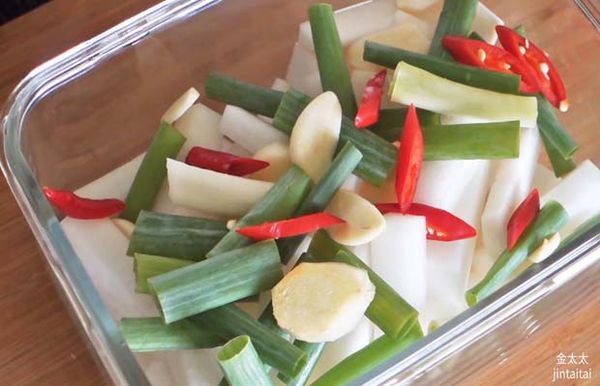 先把醃好的蘿蔔放入保鮮盒，然後加入其他切好的材料。
