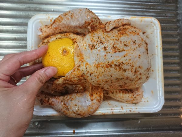 檸檬在桌面用手大力壓滾至軟，再用叉子或竹籤均勻插一插，將蒜頭與檸檬塞進雞肚內，再用竹籤封口。