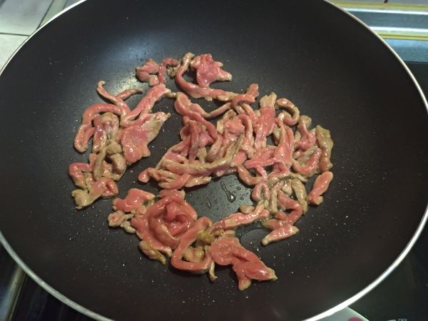 起油鍋小火先將牛肉炒至3~4分熟，倒出備用。