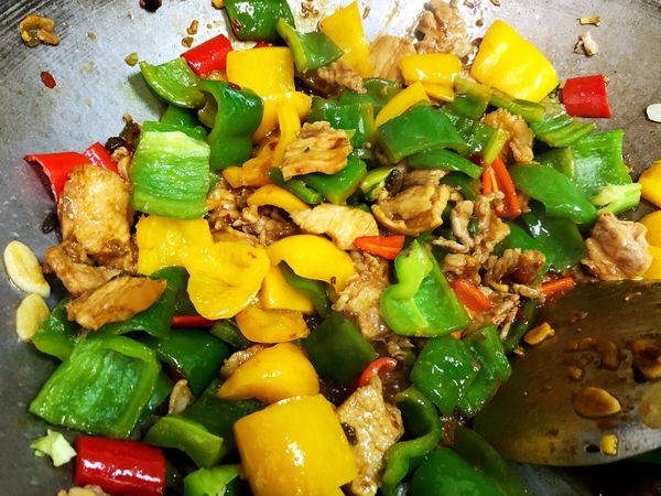 翻炒至香氣四溢，下濾乾水分的甜椒、青椒，再下少許白醋與黃酒，大火翻炒至完成。