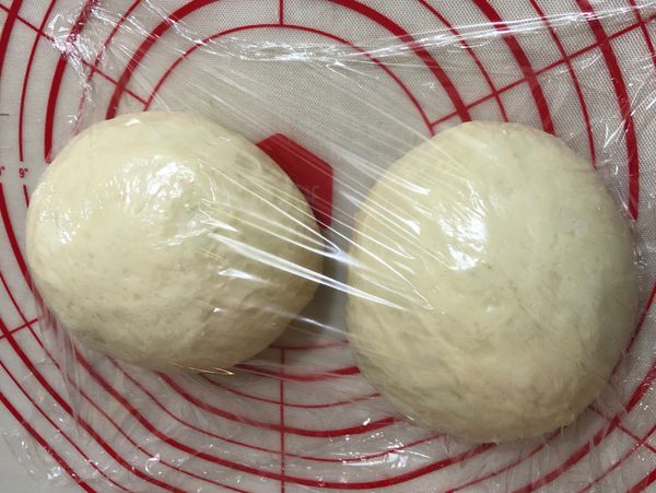 麵糰表面會呈現光滑，發酵約60分鐘(第一次)，長大二倍大，完成後取出拍打出氣泡，分割成二個揉圓，蓋上保鮮模鬆弛10分鐘。
