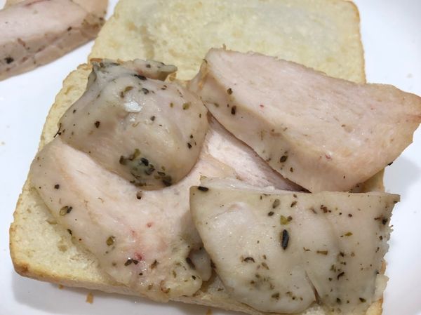 把麵包對半切開，放入烤箱加熱約5分鐘。
雞胸肉切片，中間過程可放入烤箱一起加熱回溫。