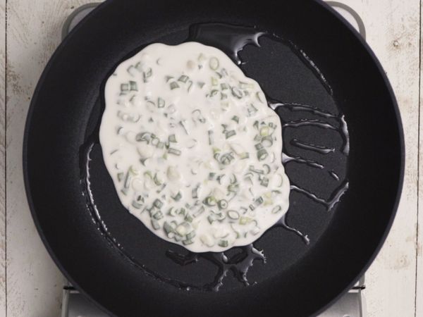 鍋中下油，倒入麵糊，擺動一下平底鍋，讓麵糊平均擴散至鍋底，以中小火慢煎至麵糊凝固，即可先取出。