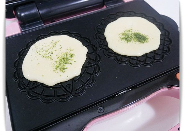 接著擠入麵糊至模內灑上海苔粉，蓋上蓋子加熱約3-4分鐘即可取出享用。