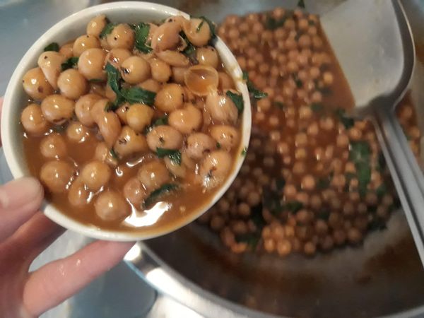 在小碟子裡裝煮好的破布子。