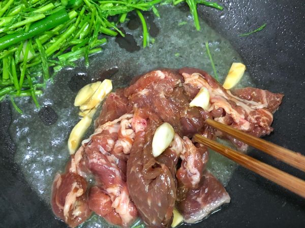 蘆筍拌炒約30秒後，先移至鍋邊
放入醃好的豬肉片