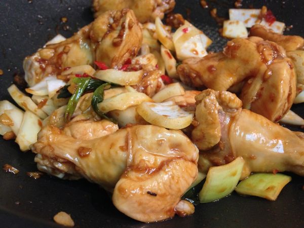 適量油熱鍋，依序將薑末、蒜末、青蔥段、辣椒丁爆香後，加入小雞腿與[調味料A]，翻炒到小雞腿上了醬色後，再丟入洋蔥丁一起拌炒出香氣。