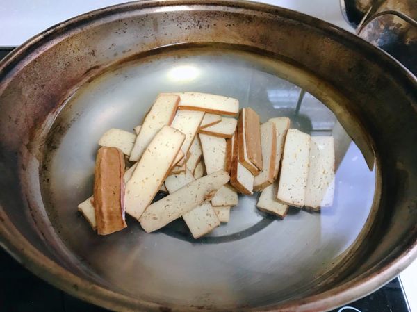 豆乾切片，用中小火煮5分鐘左右，撈起泡在冰水裡備用。