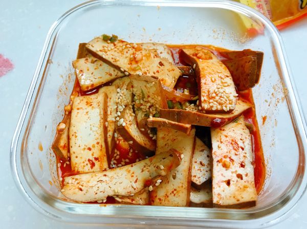 豆乾瀝乾水後，與醬汁、薑末、蒜末、蔥末和芝麻混合均勻。