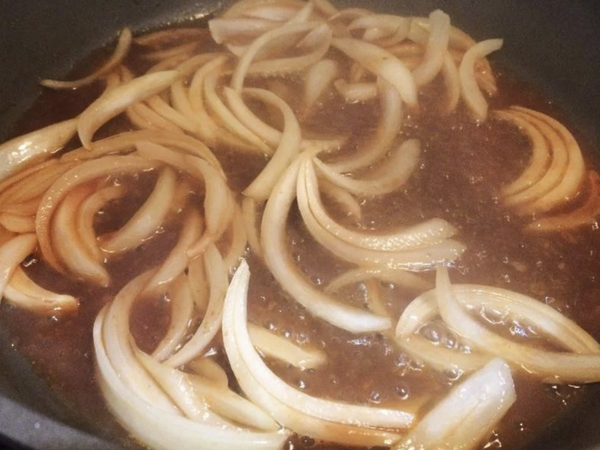 準備另一個鍋子，把1大匙油跟番茄醬放入鍋中炒香，再放入糖，醋，清水，洋蔥，拌炒至醬汁滾。