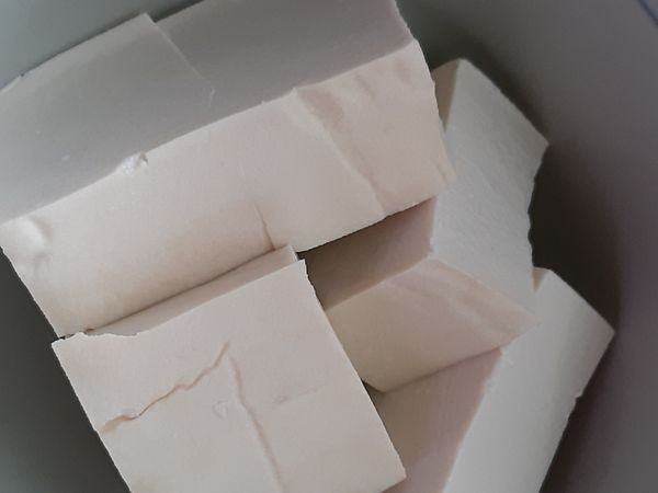 錦豆腐取4/1，切成塊狀，和金針菇一起放入鍋中。