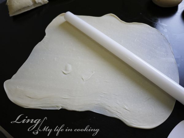 桌面上抹上沙拉油防沾黏，將小麵團壓扁，再用桿麵棍壓成薄片。