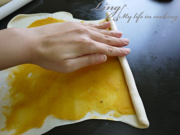 從邊邊捲起來，捲成長條狀，拉住麵團的兩端，
往桌面上甩拉，拉長一點。