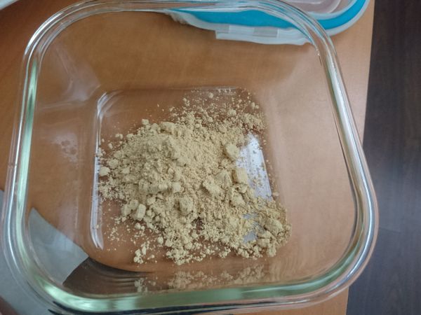 在有蓋子的保鮮盒中加入黃豆粉，多一點兒