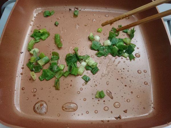 把魚片先拿起來，用餘下的油 (如果不夠就再加) 爆香蔥花。