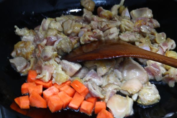 熱油鍋，雞肉、紅蘿蔔炒，炒至肉7-8分熟。