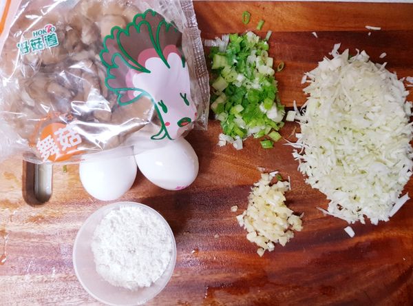 先把舞菇一根根撕開，高麗菜80g切細絲，蒜頭三瓣和青蔥兩根切末，並準備雞蛋兩個和麵粉一杯