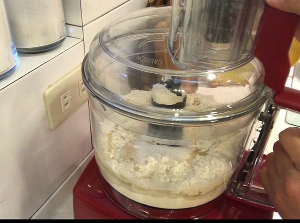 將碗蓋含進料管依逆時針方向轉入，咔嚓一聲至定位，按下啟動打麵糰。