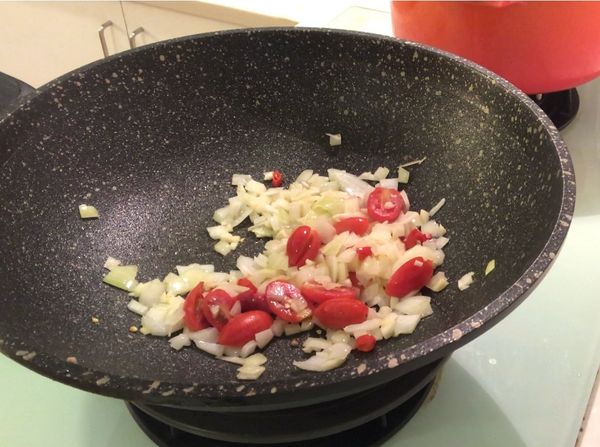 再加入小蕃茄、辣椒末拌炒出香味。