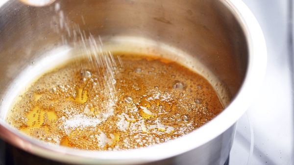 當糖漿的顏色從金黃色變成漂亮的琥珀色時，要立刻關火移鍋，加入鹽和一點滾水來稀釋焦糖，但要小心焦糖會噴賤，請保持距離以策安全