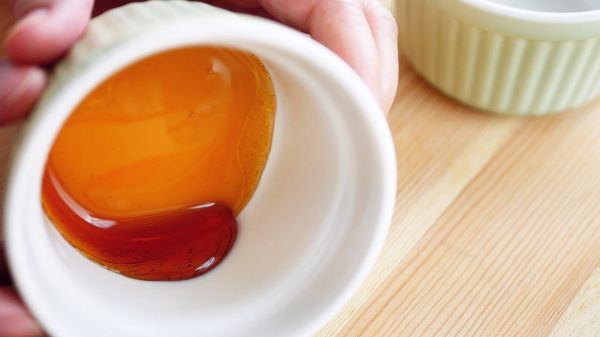 待焦糖不噴濺了，趁熱把焦糖倒進烤盅裡，轉動烤盅, 讓焦糖均勻附著在邊緣