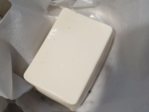 在蒸鍋裡面放冷水，然後將豆腐放到蒸鍋中，待水滾即可拿出。拿出來時記得小心的把豆腐周圍多餘的水分倒掉唷。
(因為只是要讓豆腐變溫熱，所以蒸的時間不用長)
(我家沒有電鍋，所以用小蒸鍋，盤子放不下所以只好墊一張烘焙紙來蒸。家裡如果有電鍋，可以將豆腐裝盤入電鍋蒸會比較方便，只要記得出鍋時要把水分去掉就好)