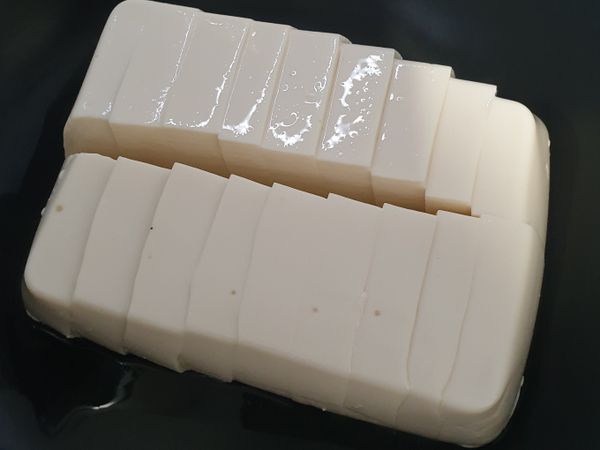 將豆腐從蒸鍋中取出，然後去掉多餘水份後切成小塊狀。