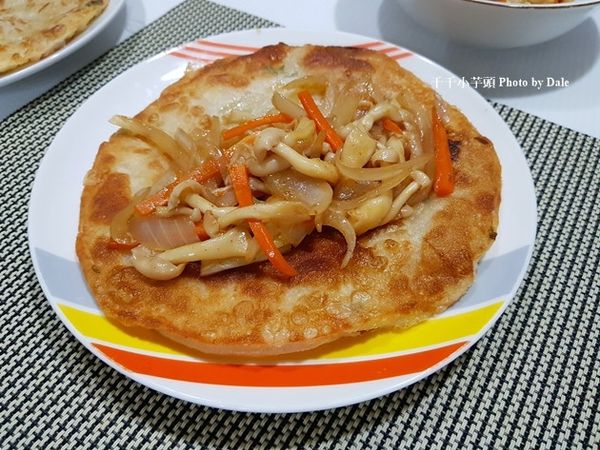 將蔥油餅放在盤裡，將炒好的菇菇放入蔥油餅中