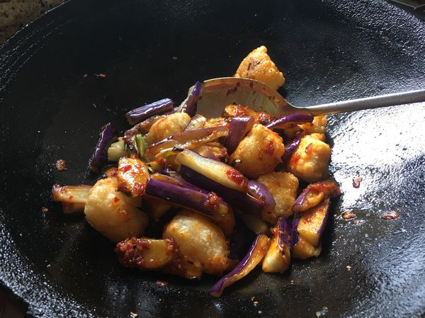 將茄子和魚塊回鍋快速炒勻。