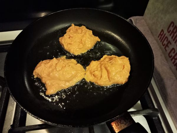 開中火熱平底鍋，倒入芥子油，用手大概抓個量，把地瓜餡輕輕放入平底鍋，煎約1分鐘，待單面成金黃色，用鍋鏟翻面。