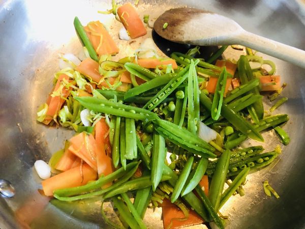 紅蘿蔔炒軟後，加入蒜片、甜豆或豌豆