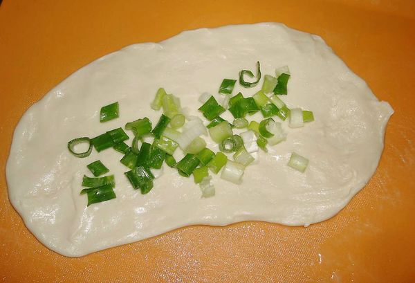 將蔥花加入少許的鹽，把麵糰攤平後，包入蔥花即可...