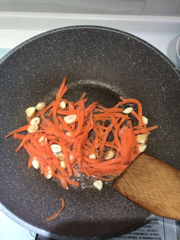 等待 香味 出來後，加入 紅蘿蔔絲 拌炒。